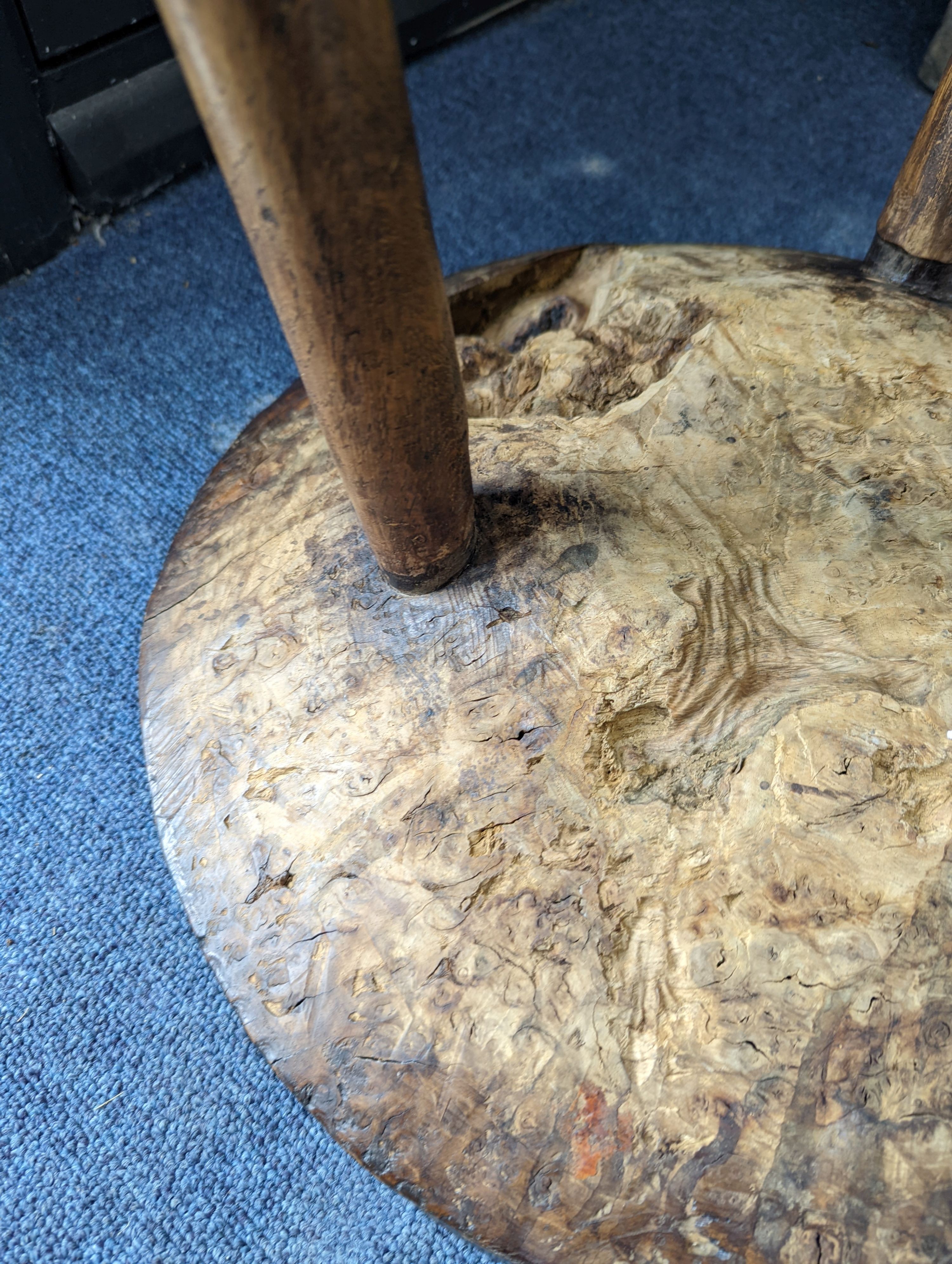 A circular burr elm and ash primitive cricket table with T shaped stretcher, diameter 44cm, height 61cm